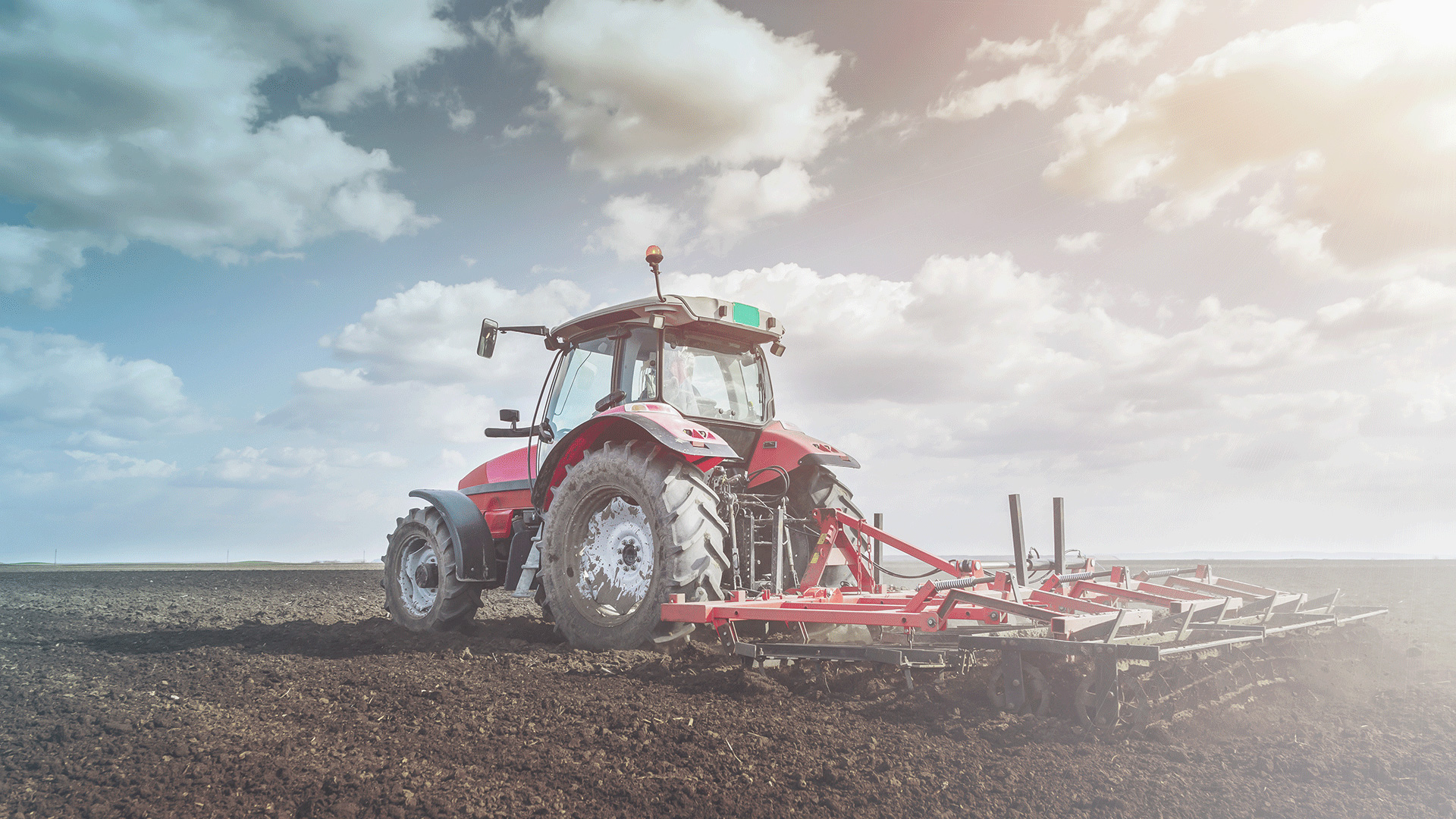 Farming tractor plowing through dirt
