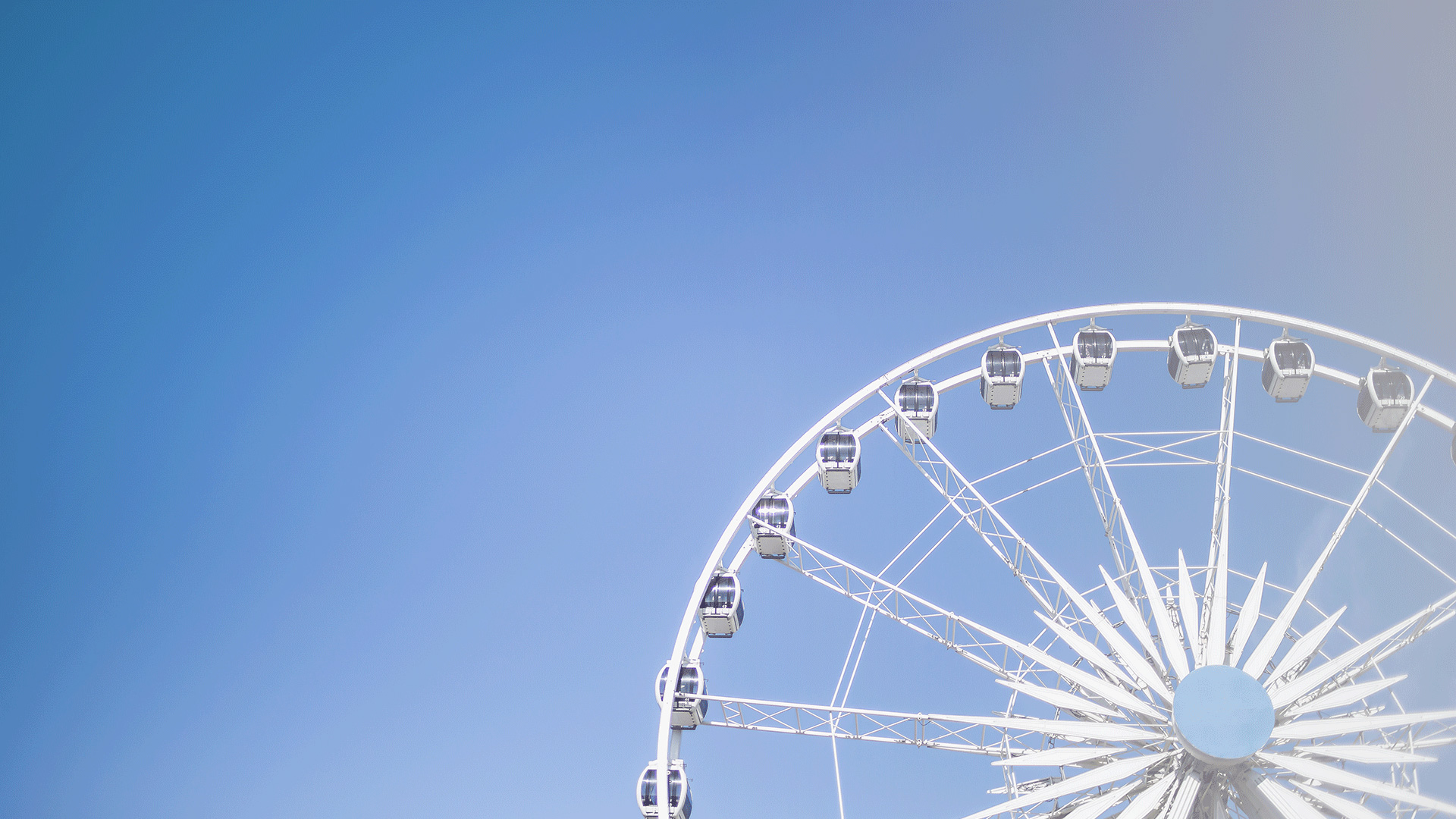 White ferris wheel in front of clear blue skies
