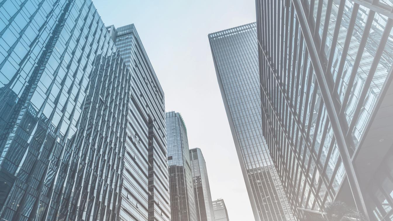 Low angle perspective of sky high glass office buildings